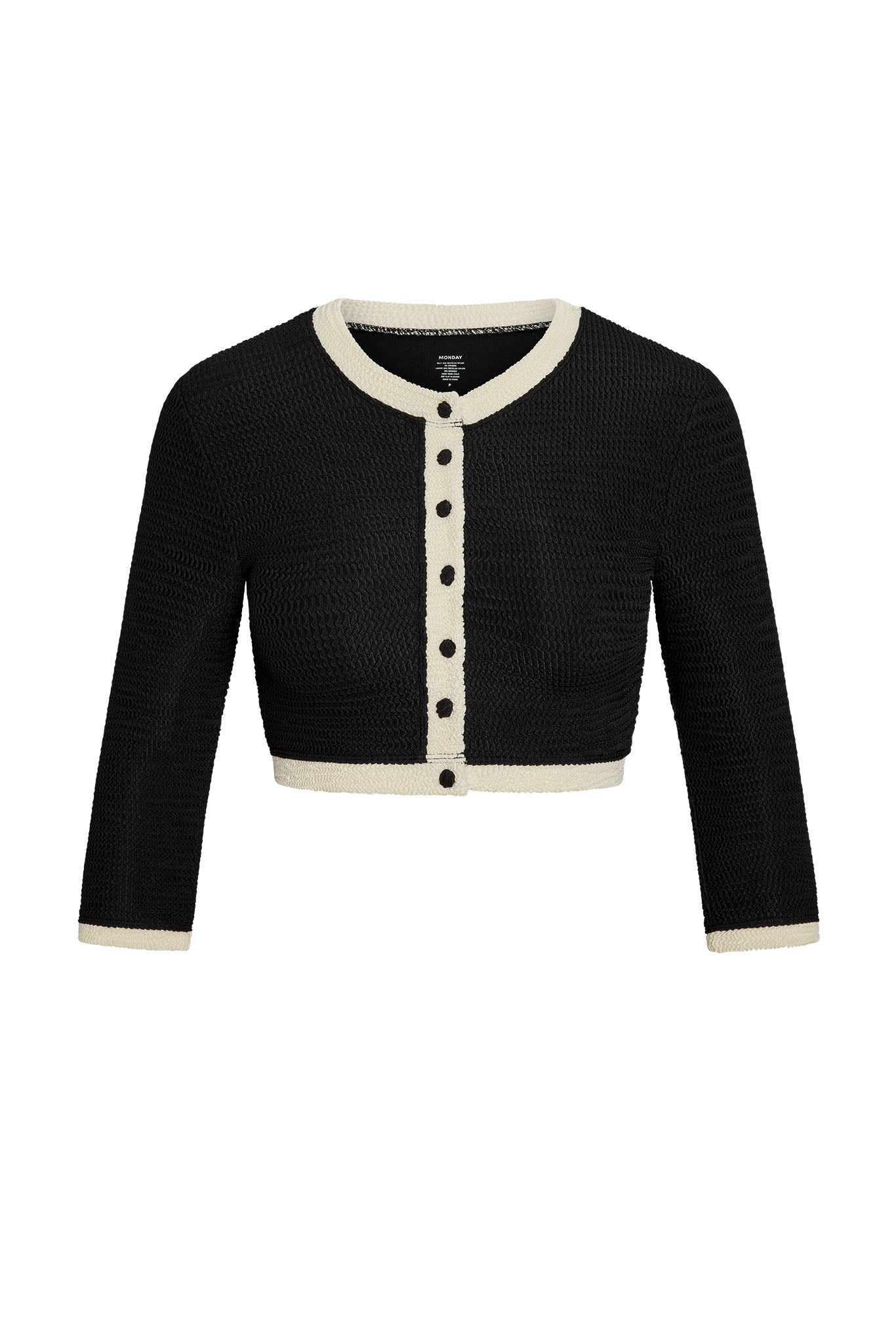 Black cropped knit cardigan with cream trim and front buttons, three-quarter sleeves; neck label reads 'MONDAY'.
