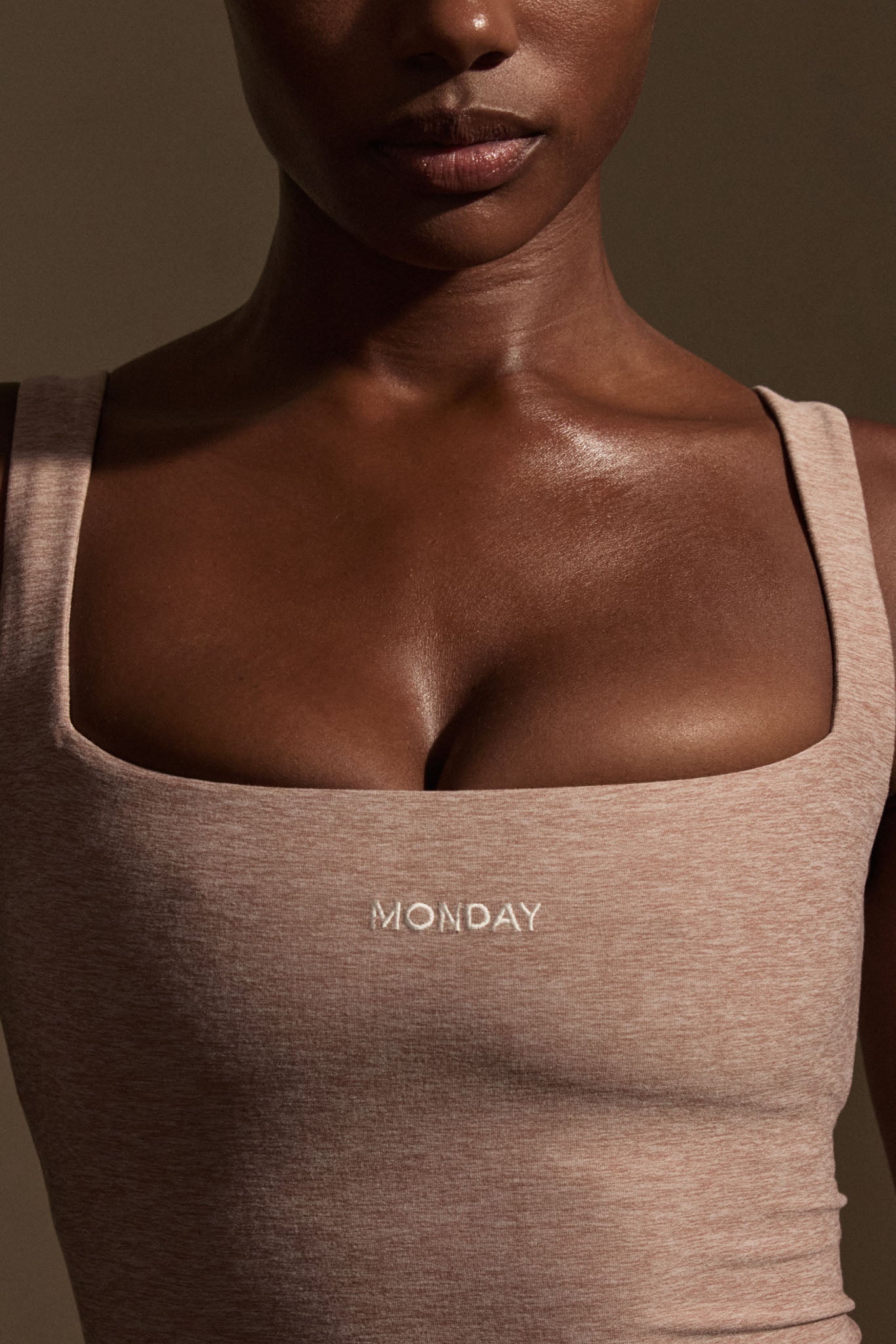 Close-up of a woman's chest wearing a square‑neck tank top embroidered MONDAY on the front.