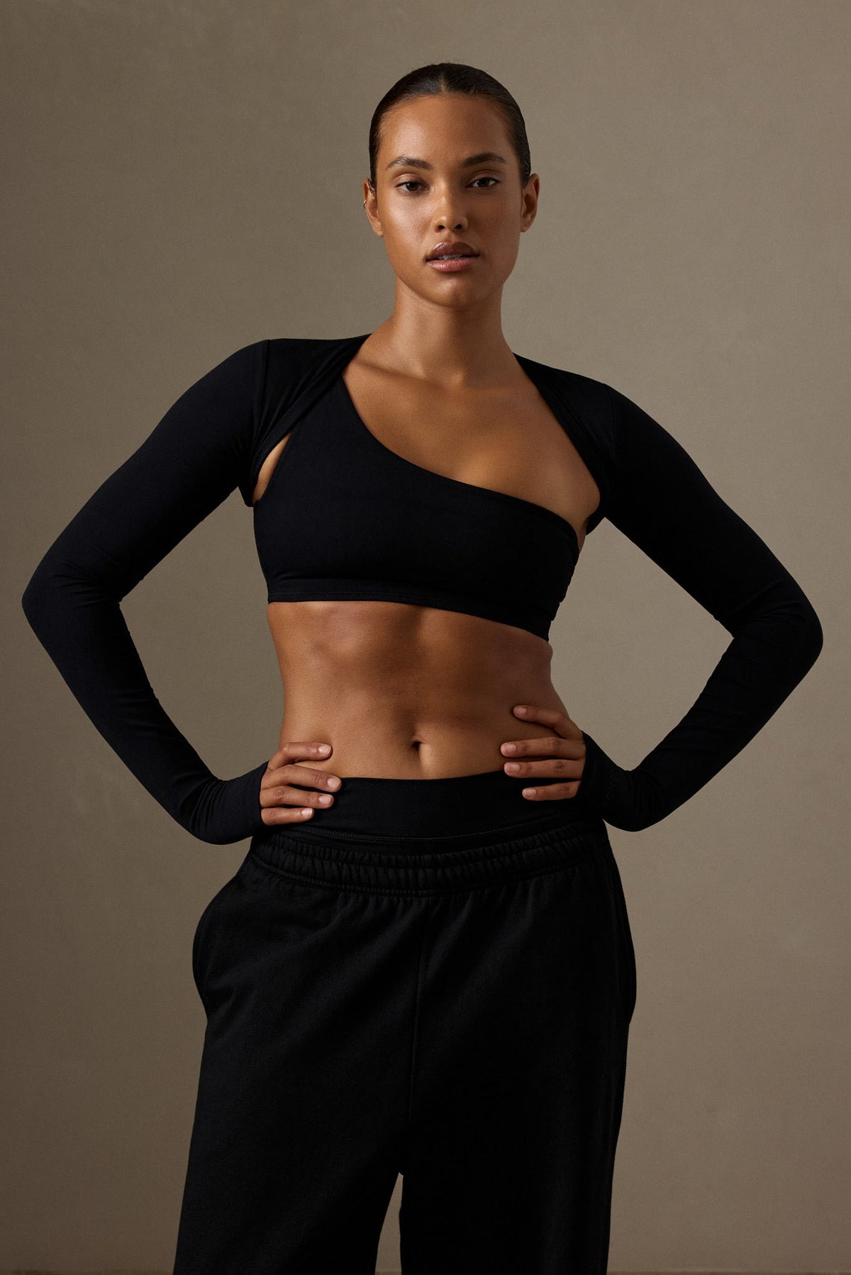 Front view of black Runyon Canyon Bolero showcasing cropped fitted cut and long sleeves on model against neutral background