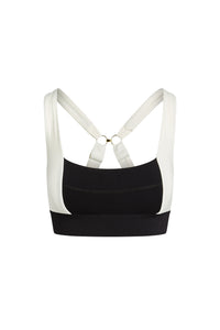 Black and white sports bra with wide band, padded cups, and crisscross back straps with gold rings.