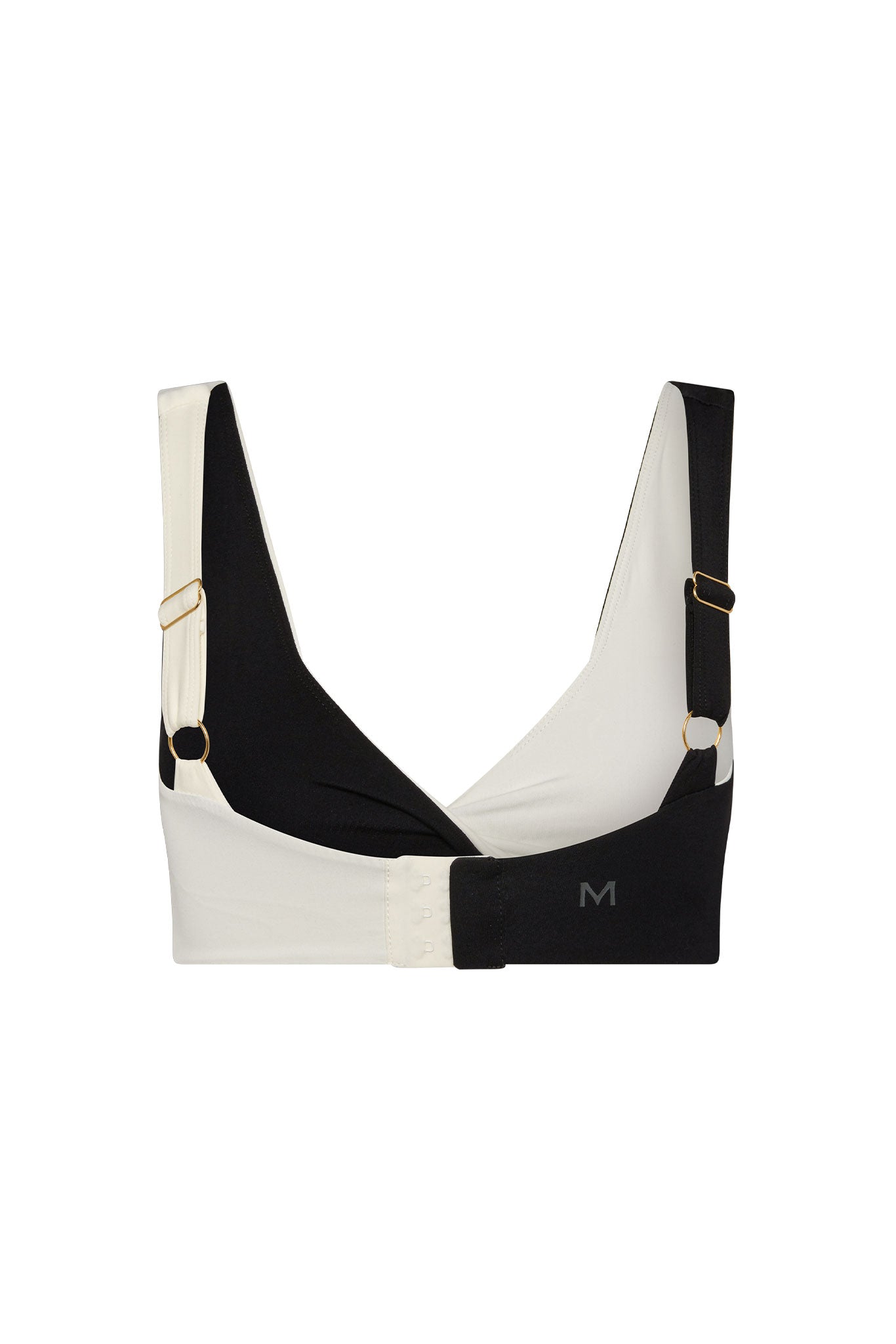 Two-tone black and white adjustable bra with gold hardware, hook-and-eye back and 'M' logo on band.