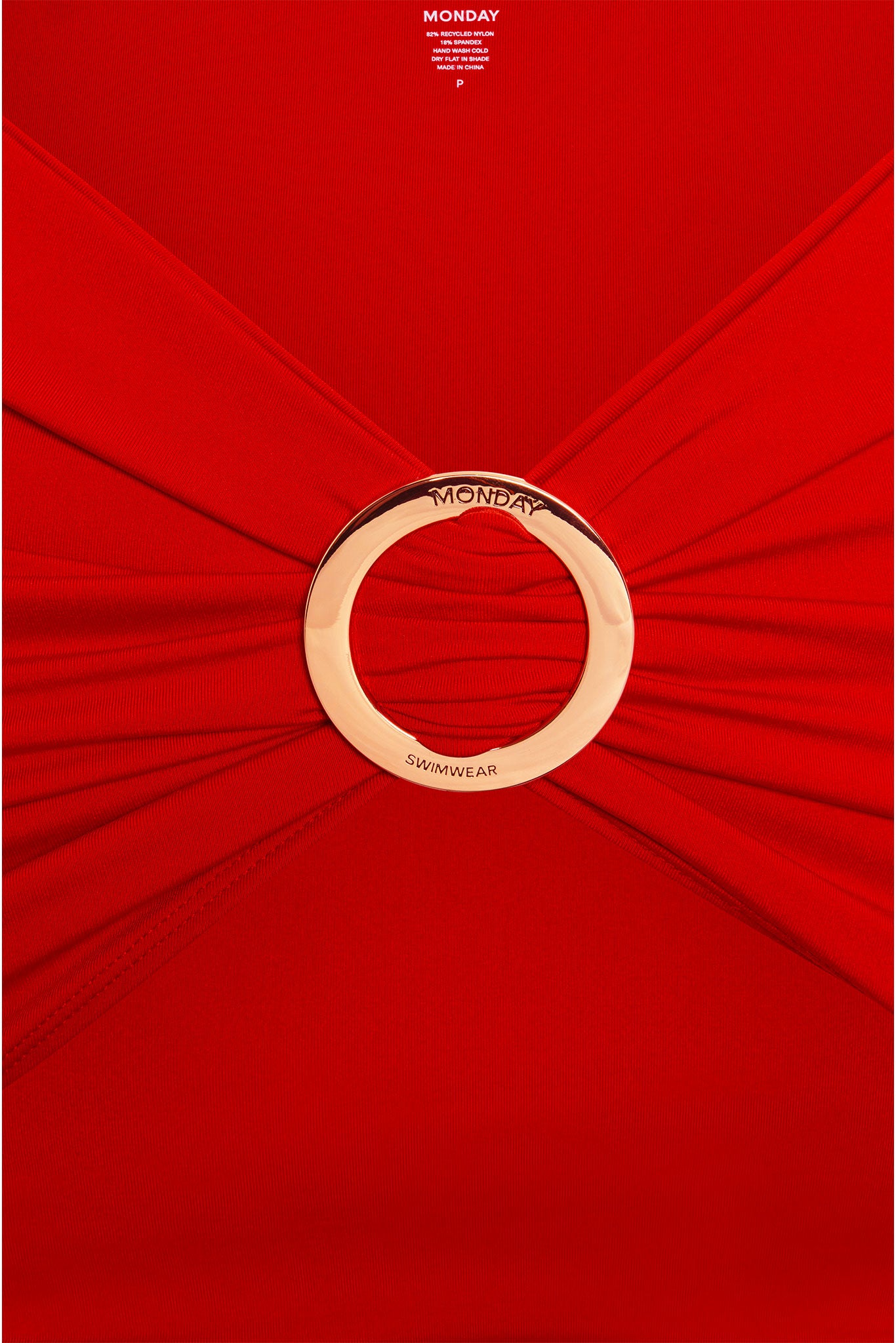 Red ruched swimsuit with gold ring engraved MONDAY and SWIMWEAR; top label reads MONDAY P