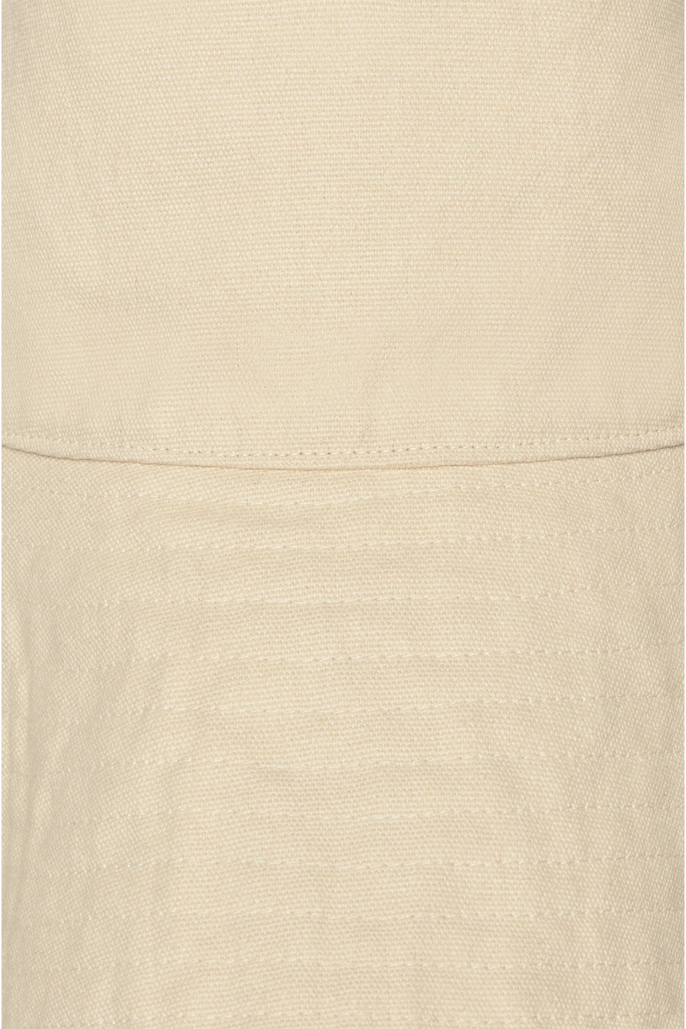 Beige woven fabric close-up with horizontal seam and parallel stitched rows.