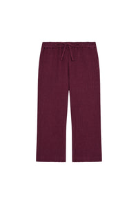 Front flat lay of Tuscany Pants Kids in fig showing smocked waistband, drawstring, crinkle texture and flare leg on white