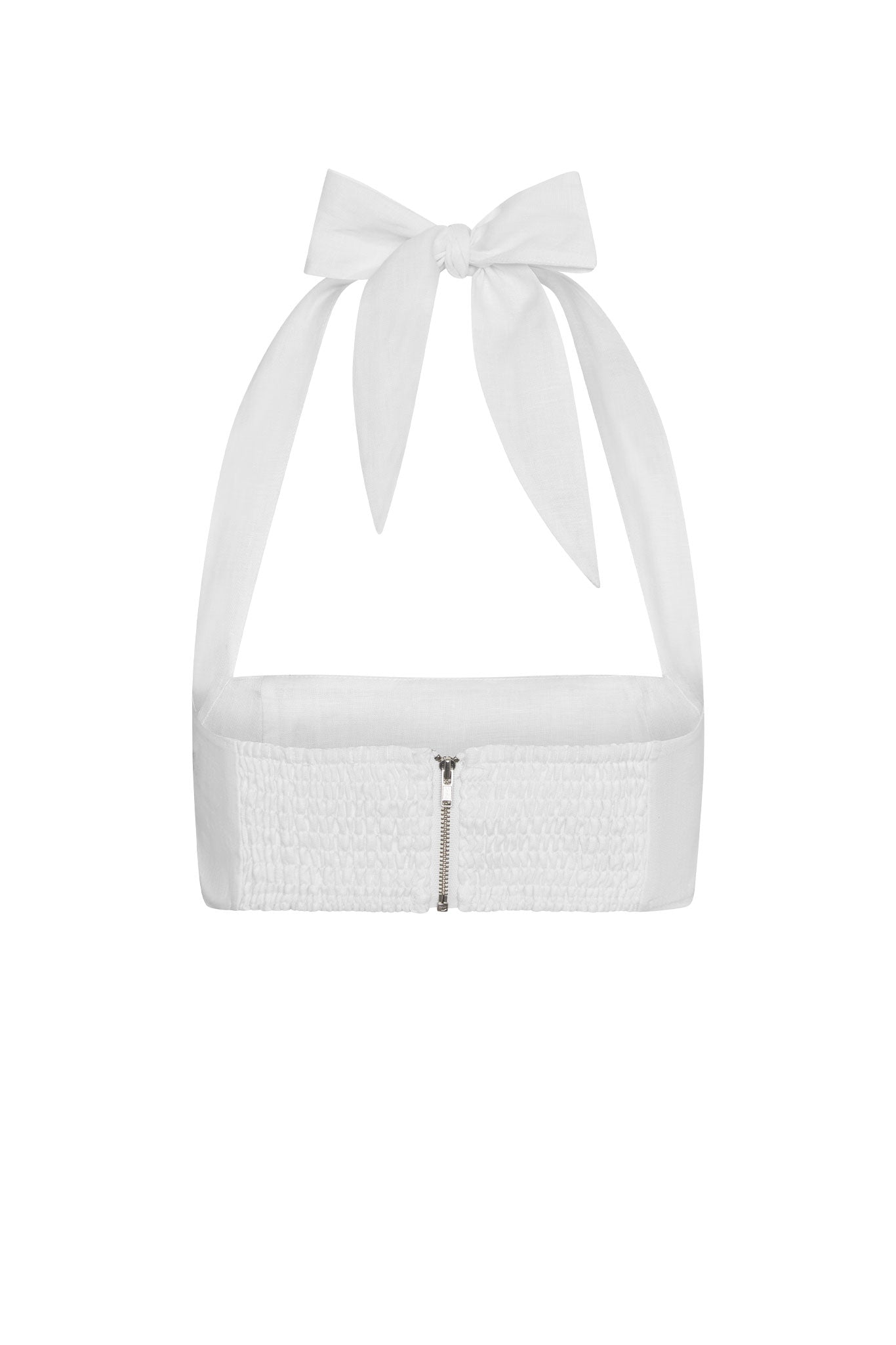 White linen halter bandeau top with front zipper, smocked band, and tied bow straps at the neck.