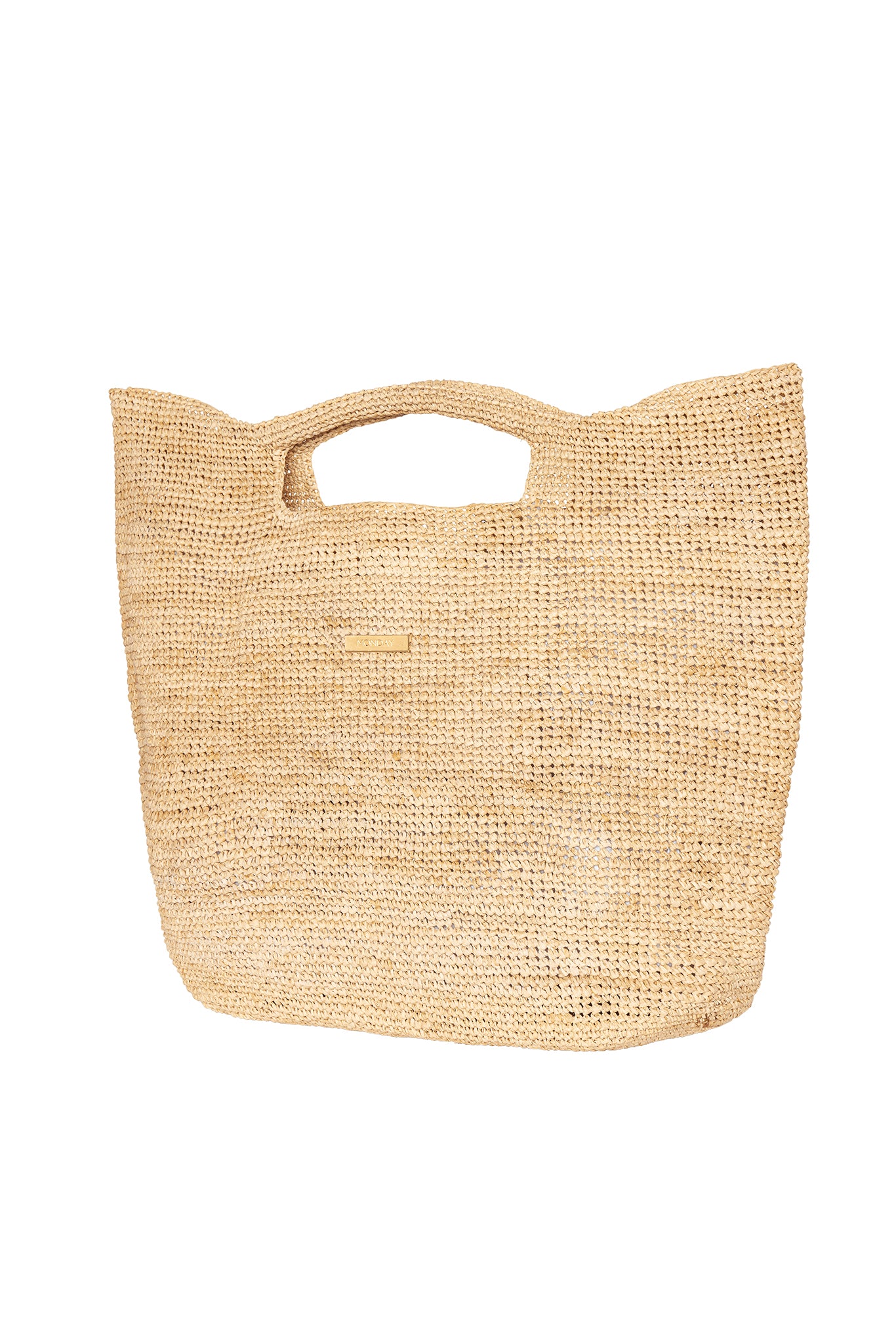 Woven straw tote bag with cutout handles and small gold logo plate reading MONDAY