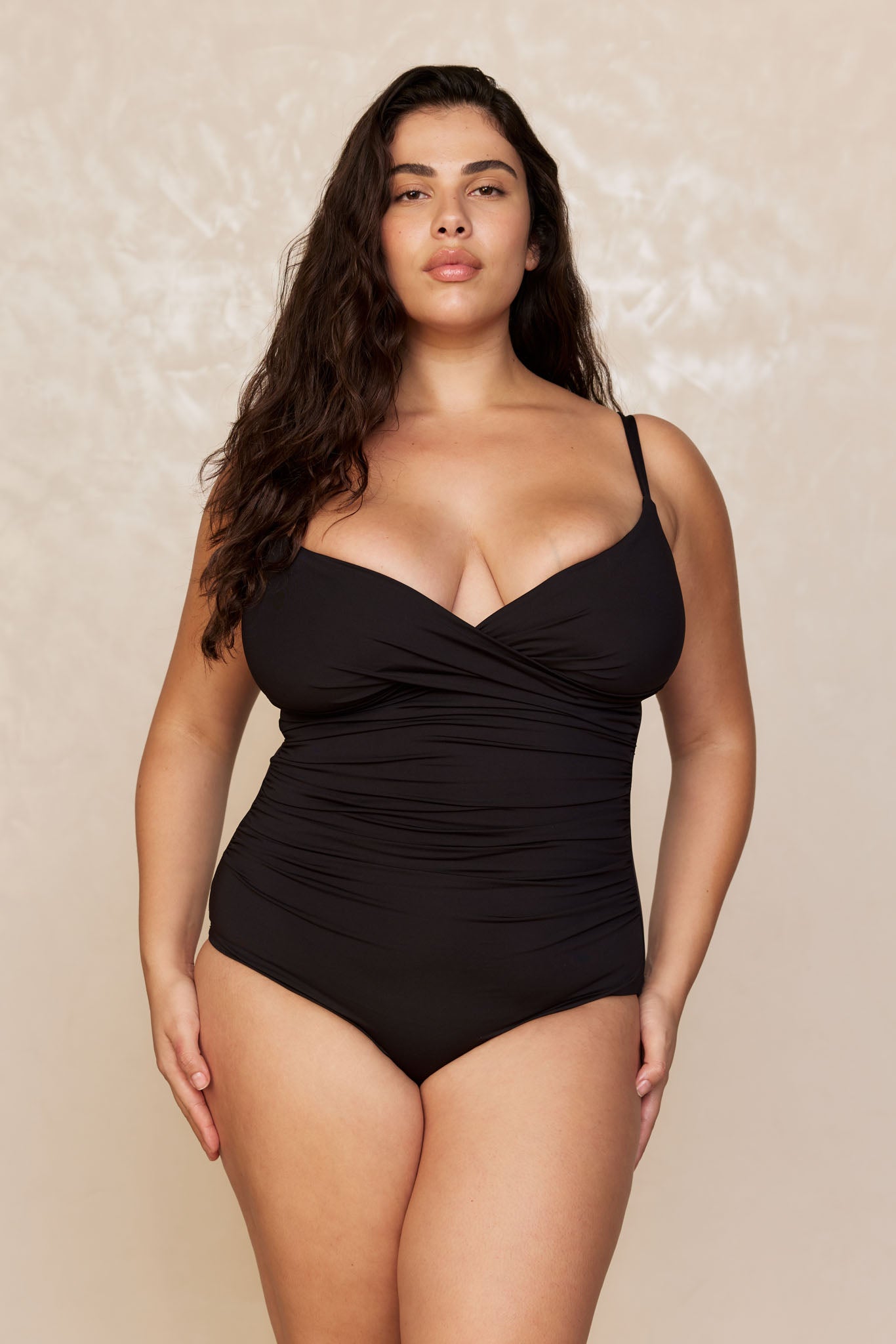 Model wearing black ruched one-piece swimsuit with spaghetti straps, front view.