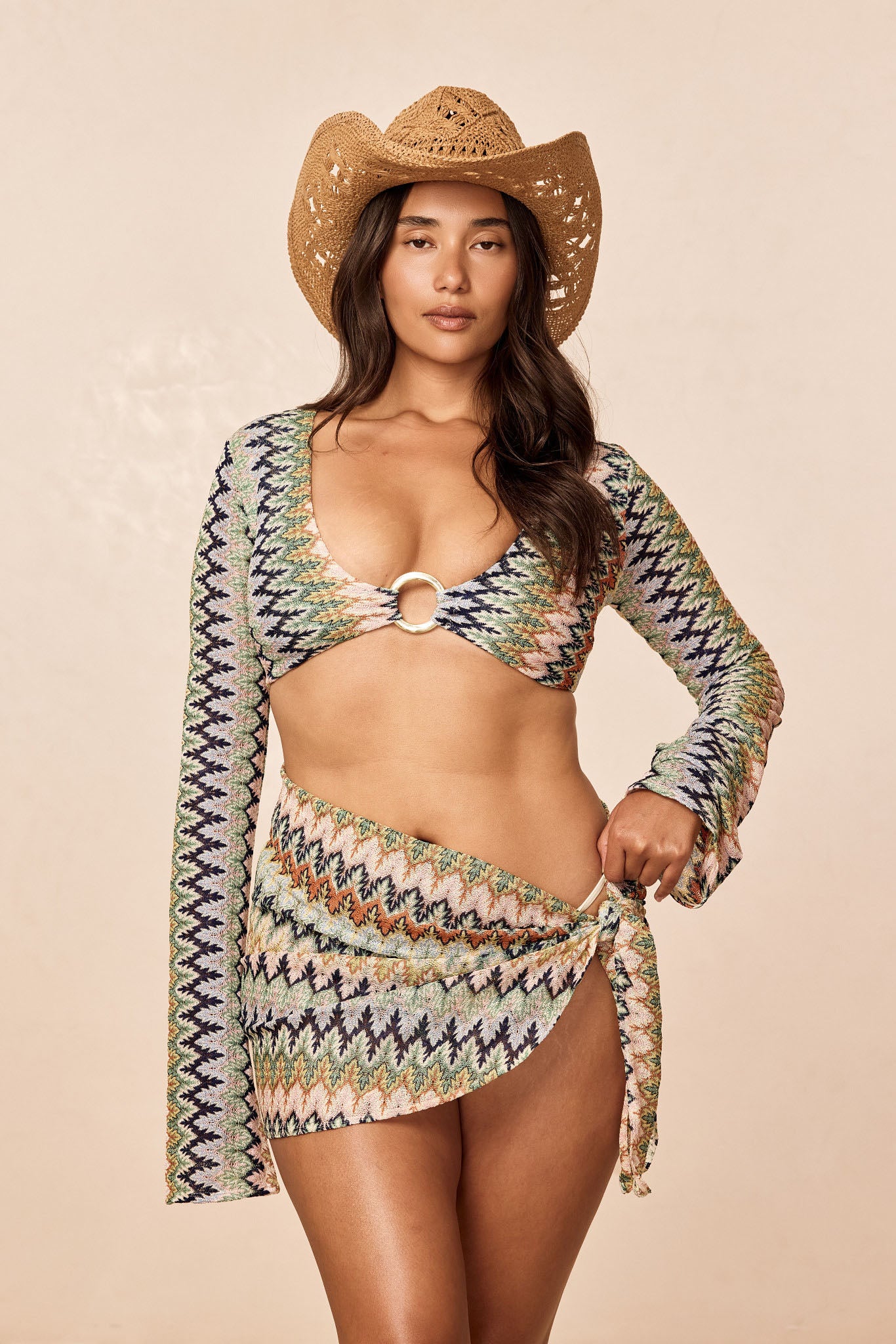 Front view of Montego Crop Top in Porto Cervo Multi showing ring-front cutout, long sleeves, and multicolor knit on a beige background