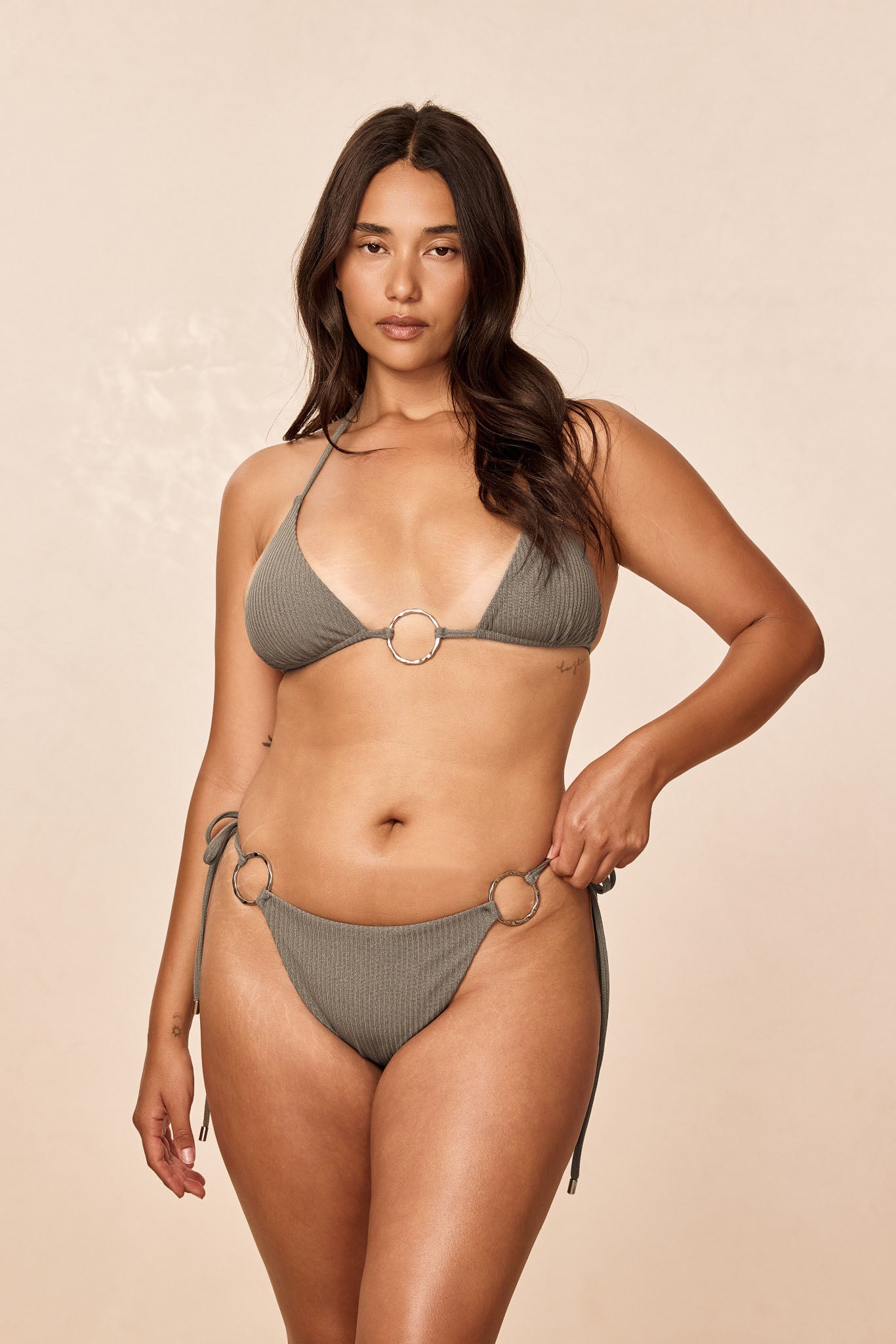 Front view of Cannes Top in Steel Lurex Rib showing ribbed lurex fabric, gold center ring, and adjustable ties