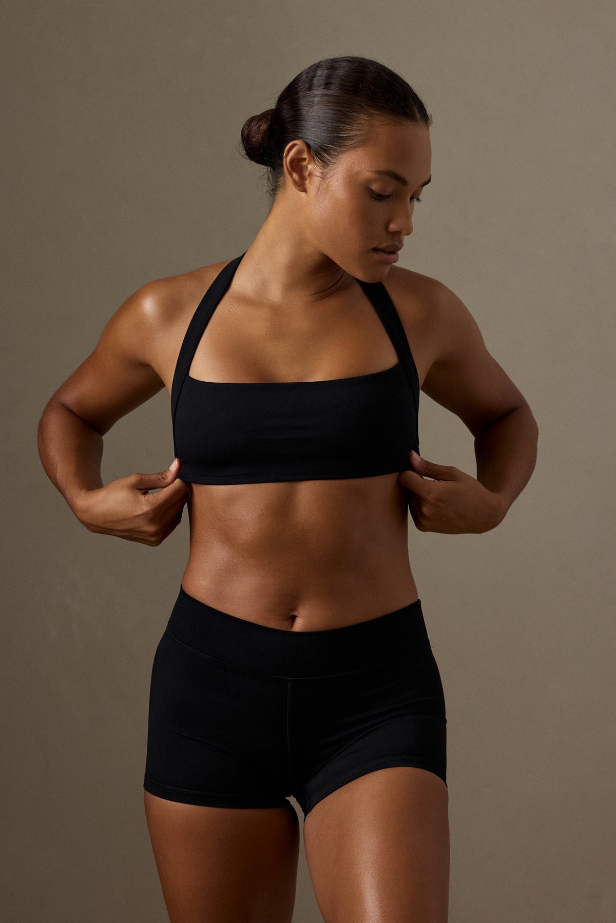 Front view of a model wearing the black Tribeca Halter Bra with wide halter straps against a neutral background