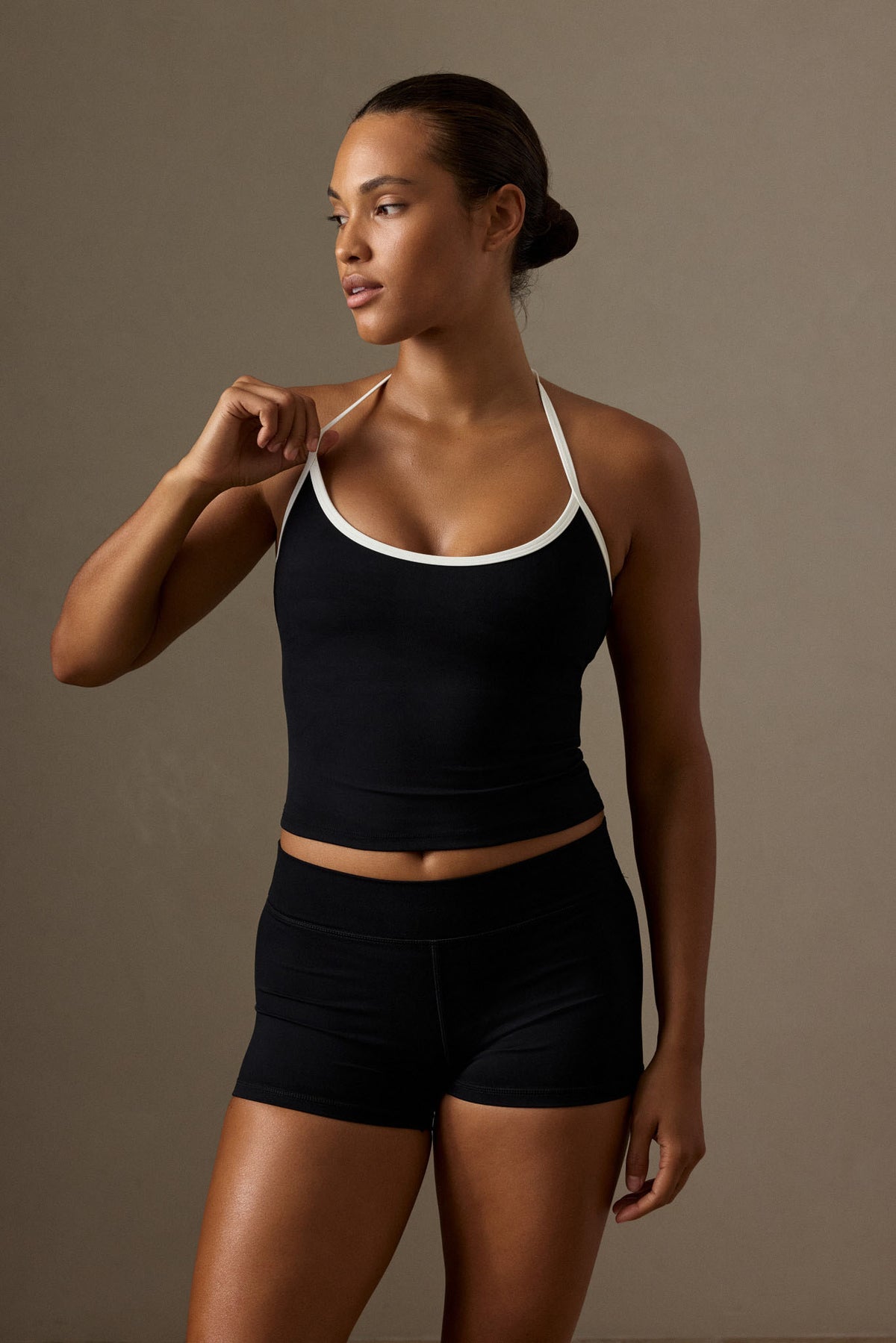 Front view of Toronto Tank in Black/Ivory worn by a model, showcasing scoop neck and halter straps against a studio background