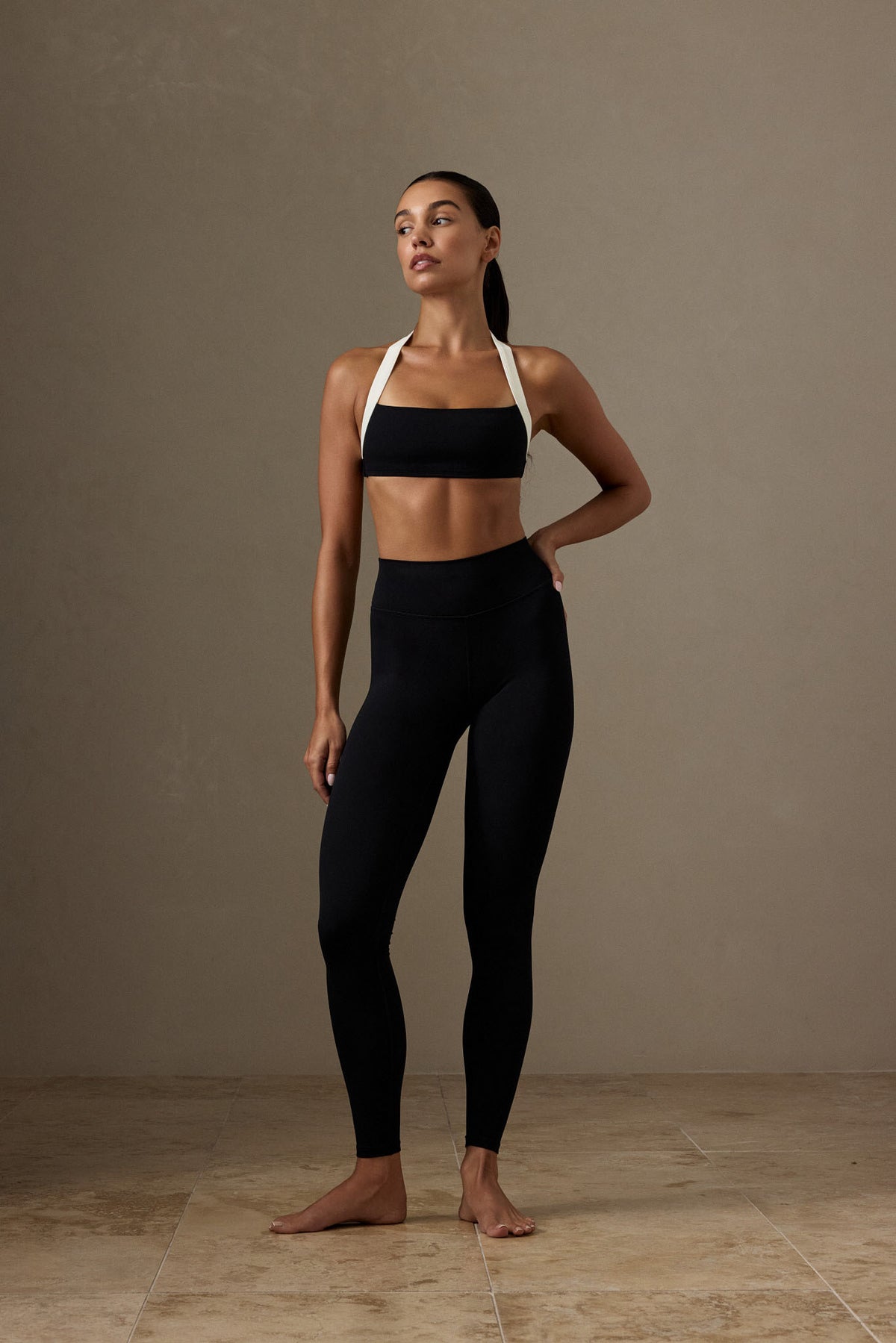 Front view of black Topanga Legging showcasing mid-rise fit and front seam on a model against a neutral studio background