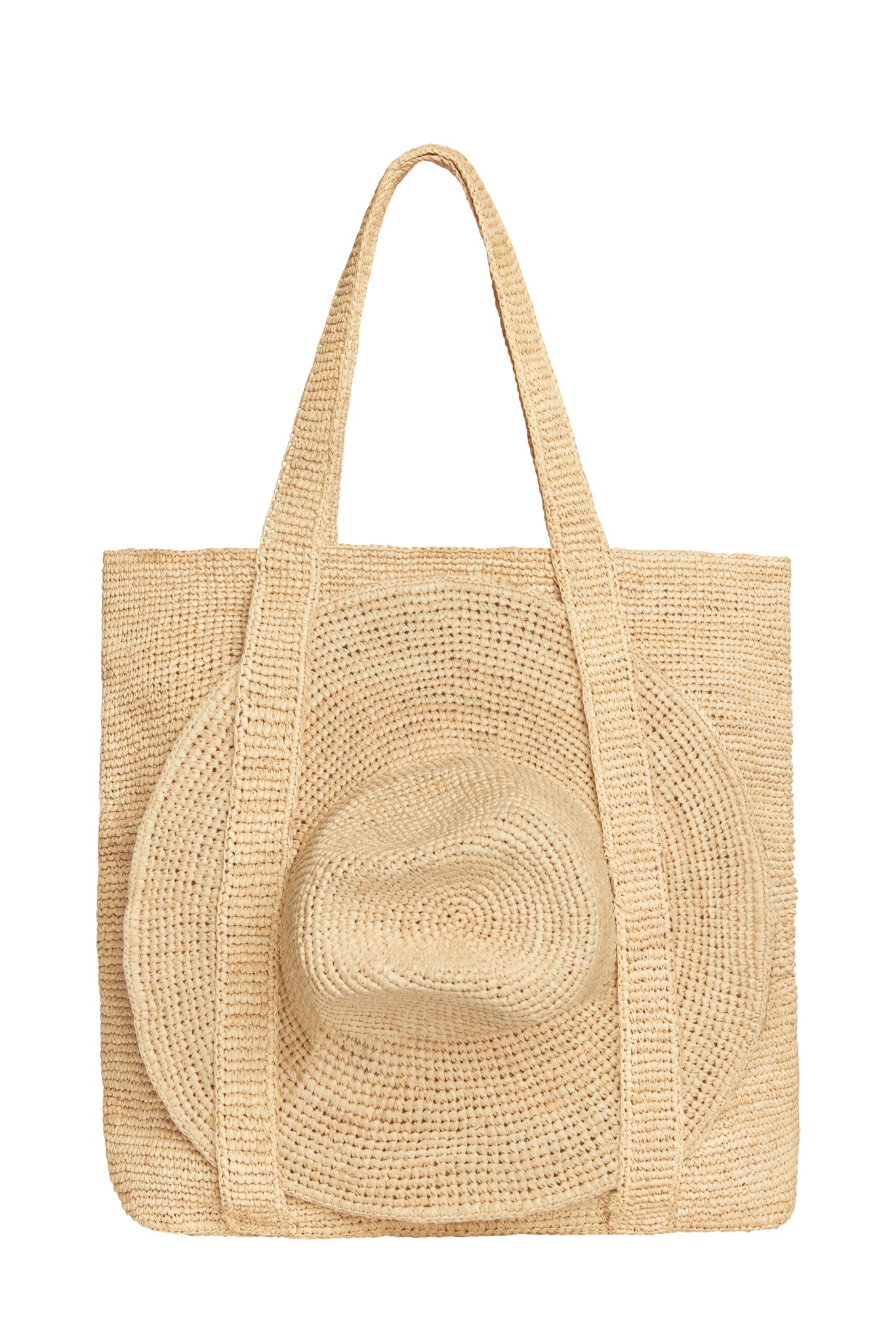Three-quarter view of Exuma Bag in Natural showing hand-crocheted raffia texture, long shoulder straps and matching raffia hat on white background