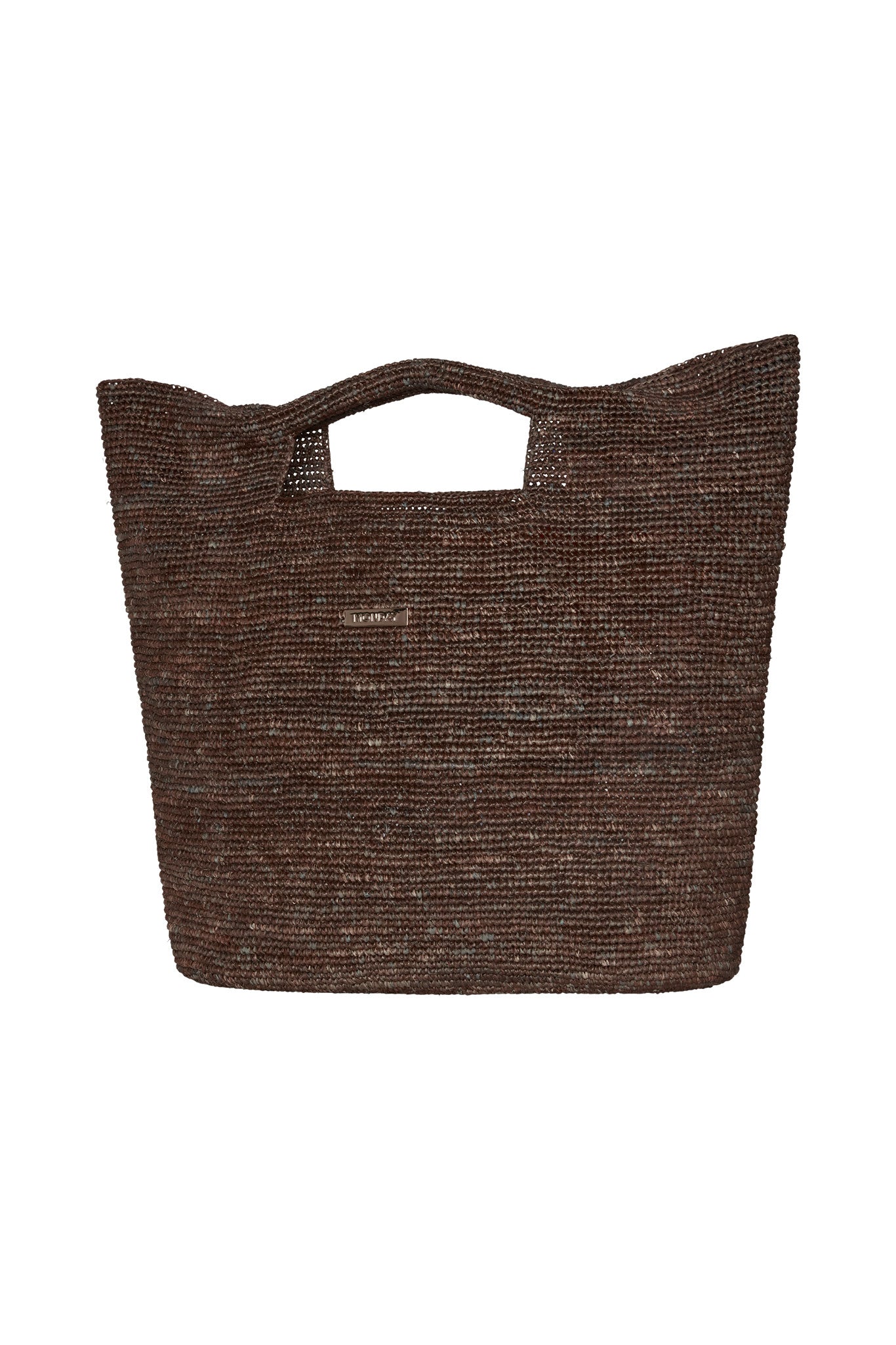 Brown woven straw tote bag with built-in cutout handle and small rectangular metal brand plaque