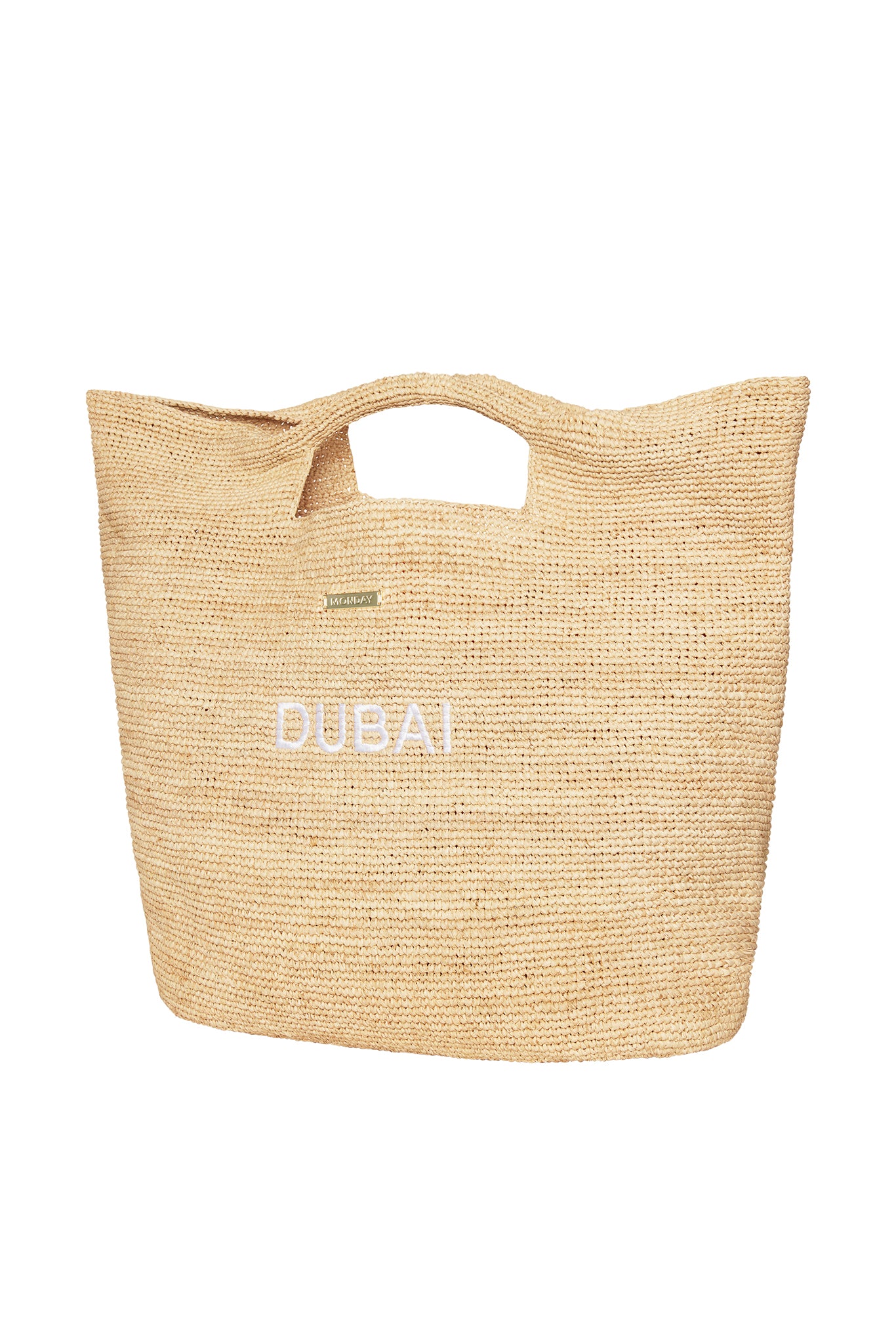Woven straw tote with cutout handles, white DUBAI embroidery and small gold MONDAY label.
