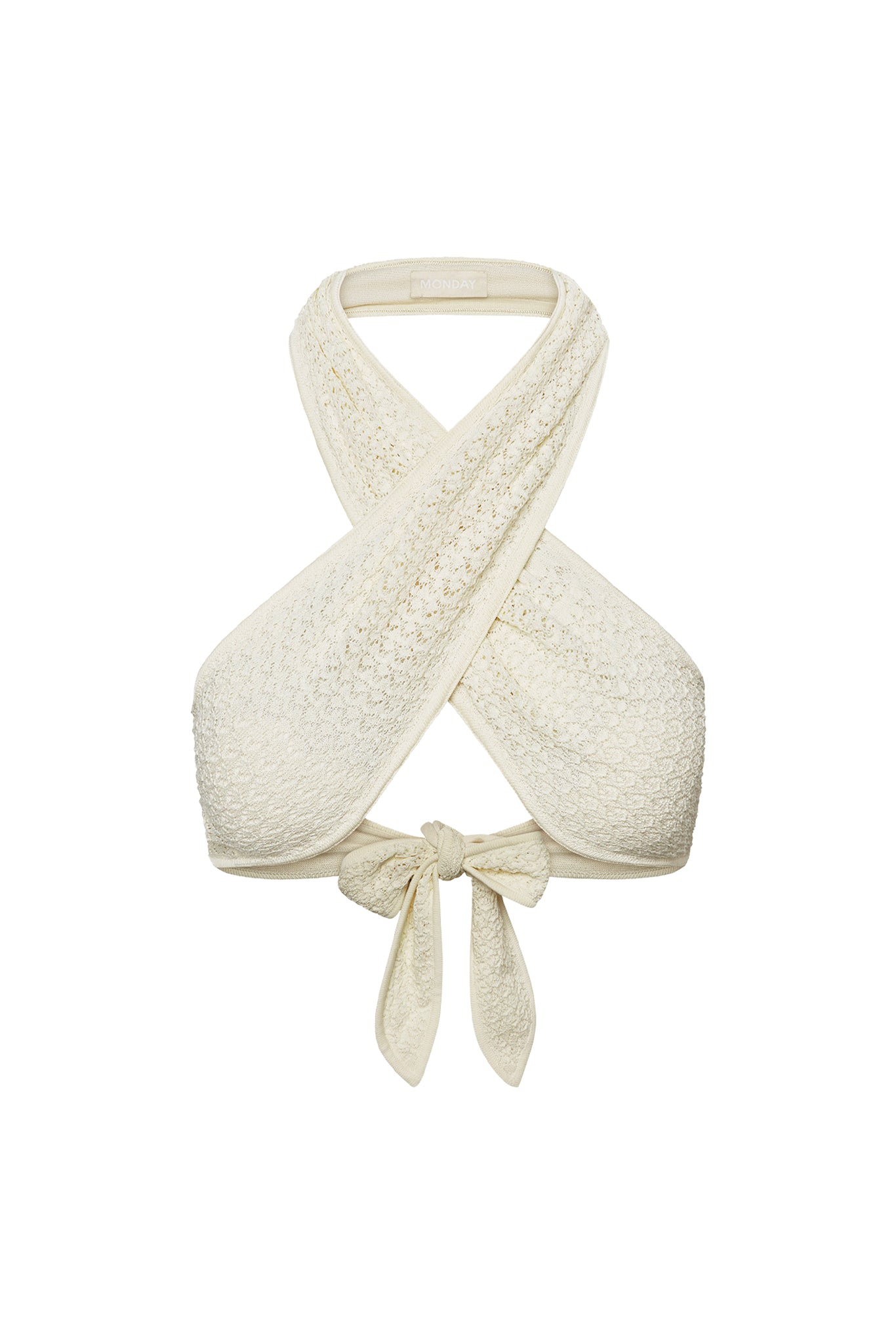 Front close up of Ramatuelle Top in ivory lace crochet showing crisscross halter wrap and tied bow on white background