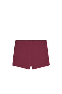 Flat lay of Santa Cruz kids shorts showcasing fig crinkle textured fabric on white background