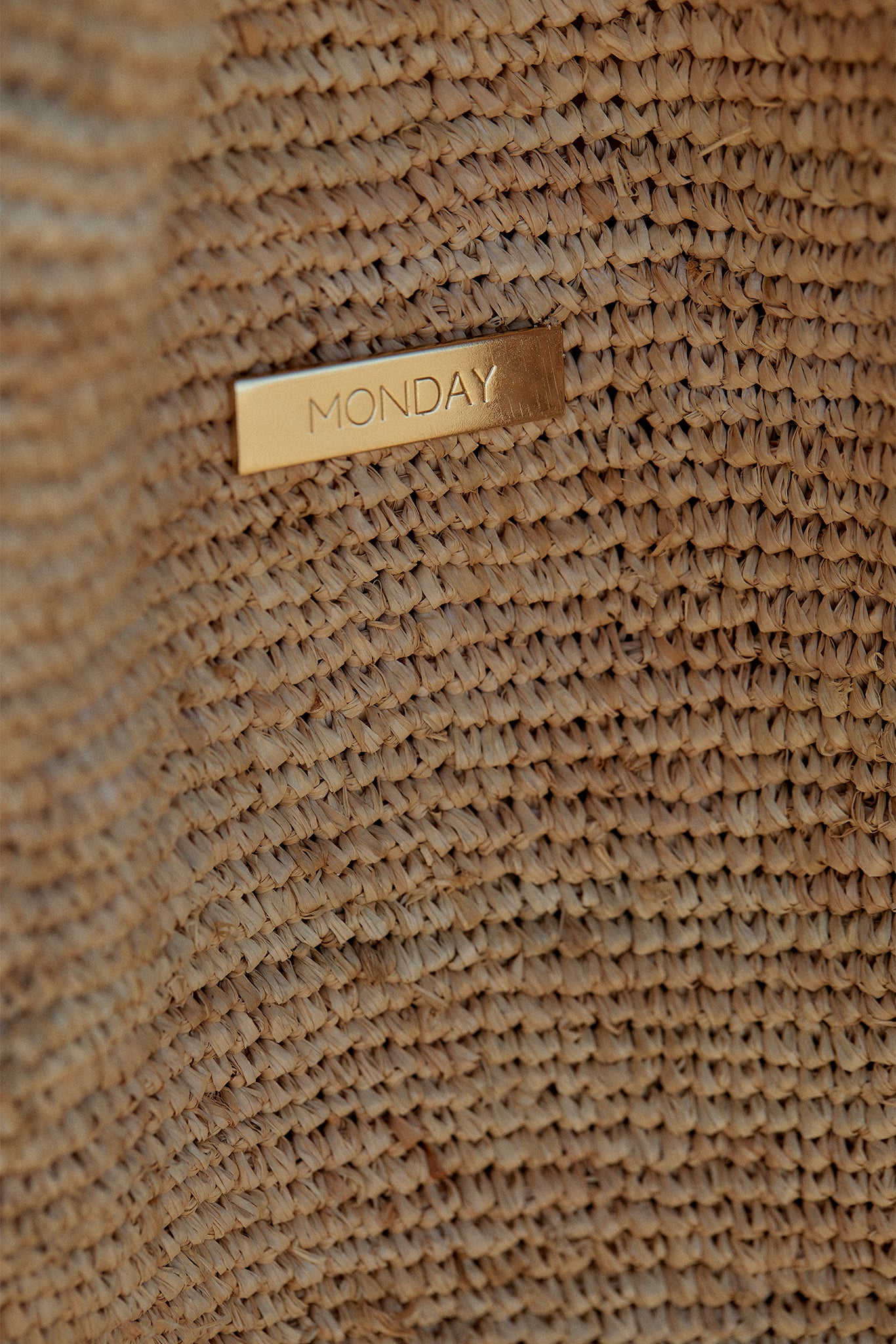 Woven straw hat with small gold tag reading MONDAY